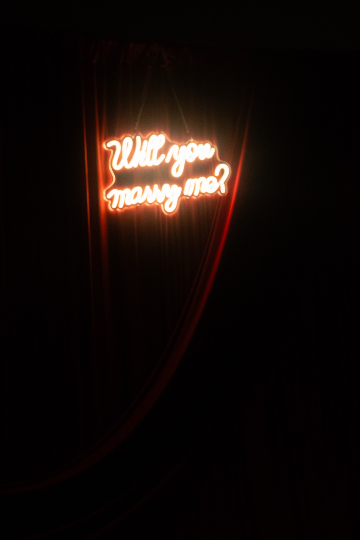 A neon sign reading will you marry me