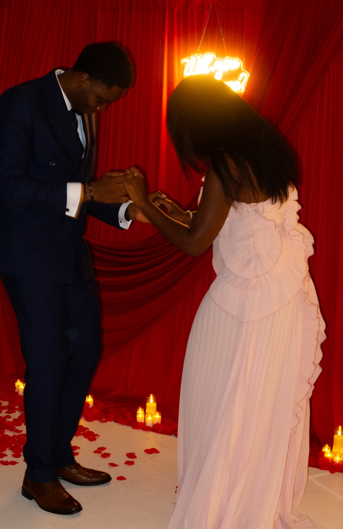 The ring going on, surrounded by candles and rose petals
